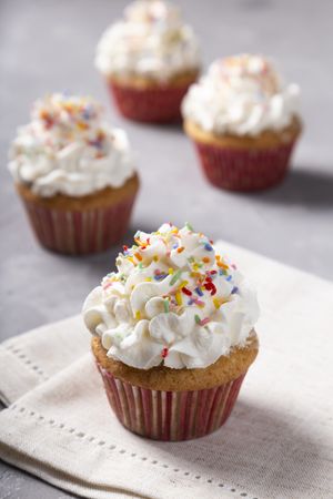 Tasty party cupcakes on the table. Cupcakes with whipped cream.