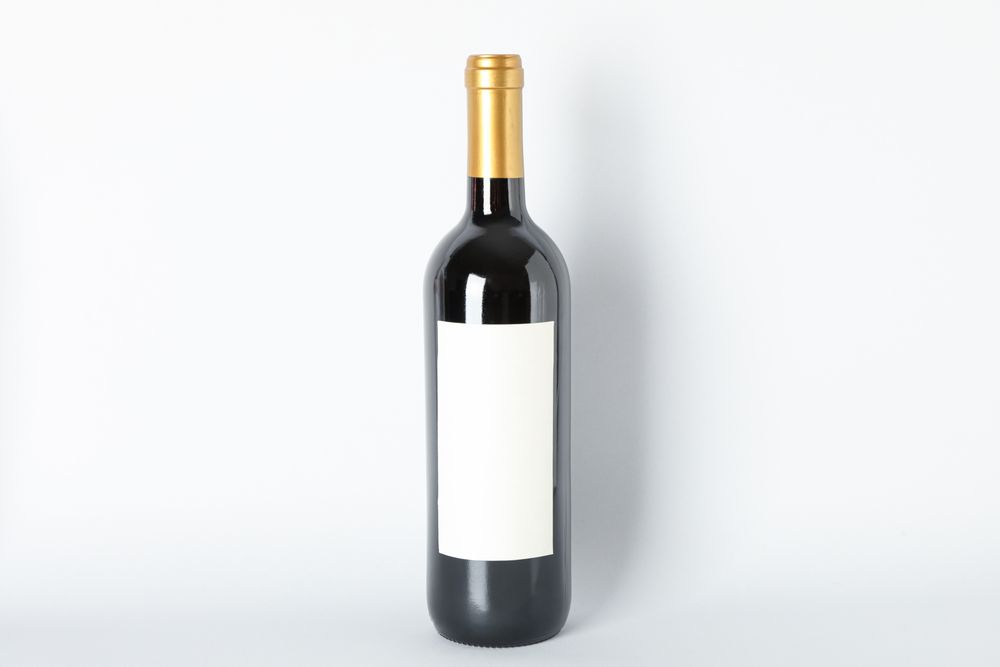 Bottle of red wine on grey background, space for text