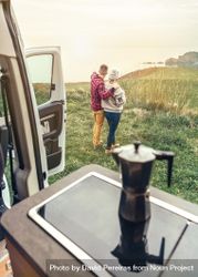 Couple enjoying beautiful morning view outside of camper van with cup of coffee, vertical 4ADwW5