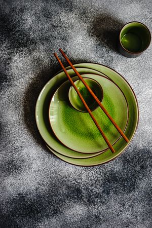 Green pile of plates with chopsticks