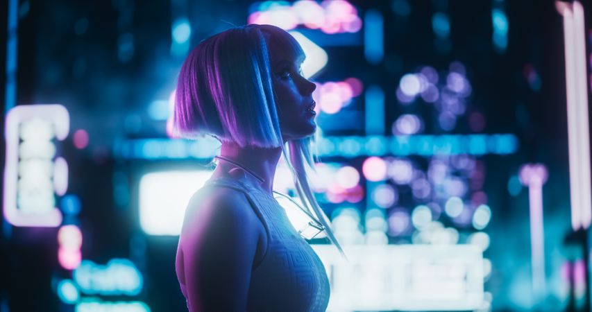 Cinematic Arc Shot of a Stylish Young Cosplay Model with Blue Hair Wandering Around a Futuristic Cybernetic City with Neon Lights. Young Excited Female in a Cyberpunk Virtual Reality