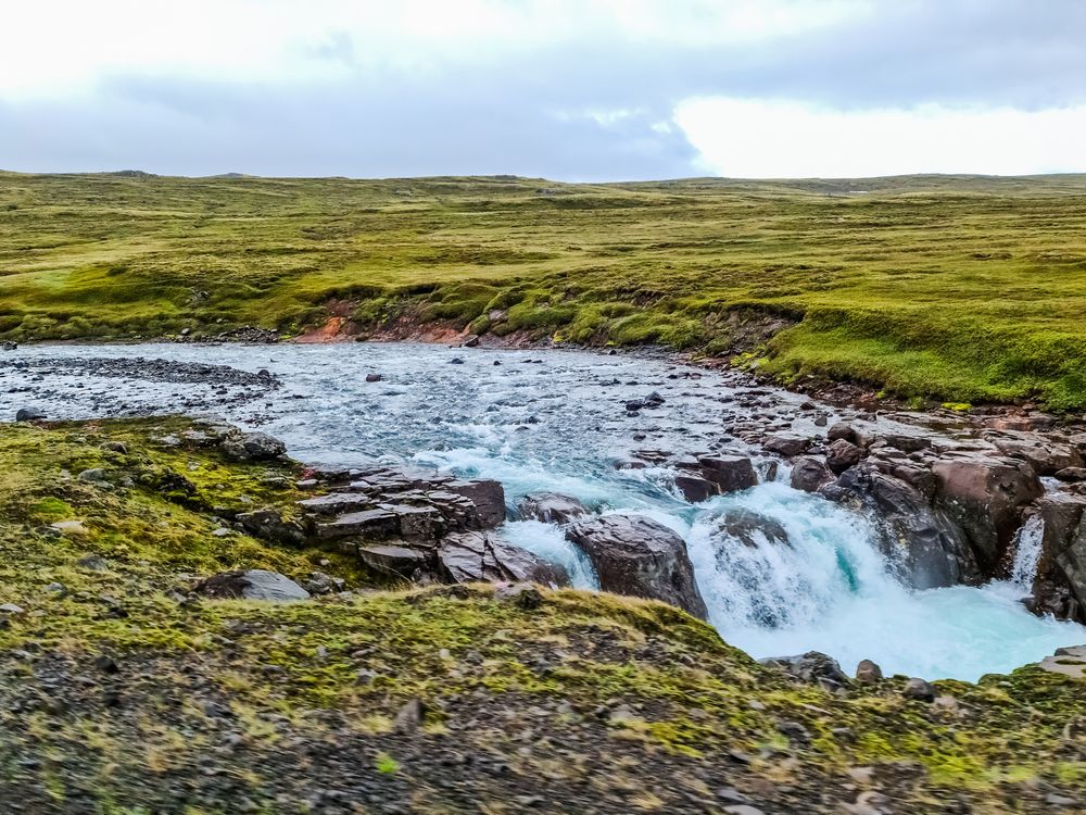 Majestic icelandic waterfall cascading through green landscape