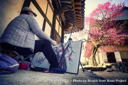 Back view of an older man drawing a cherry blossom tree outdoor 5QMNm5