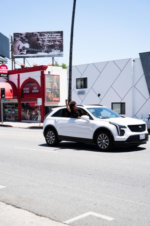 Los Angeles, CA, USA — June 14th, 2020: woman hangs out of car with her fist up at BLM protest