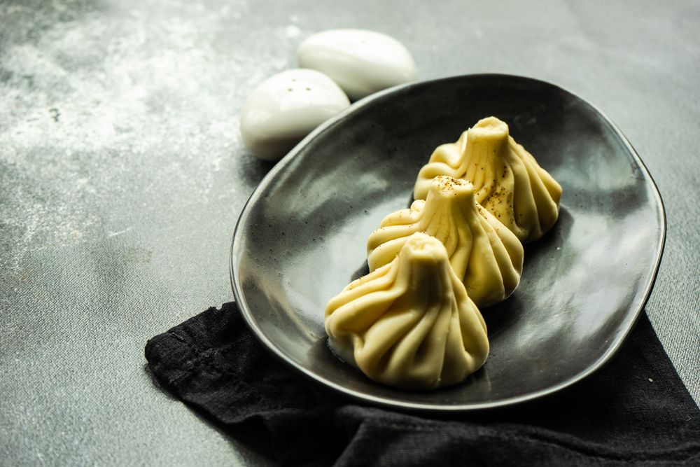 Plate of three Georgian khinkali dumplings with copy space