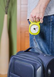 Man checking luggage weight with steelyard balance