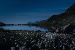 Stones on shore of crystal lake in twilight in mountains