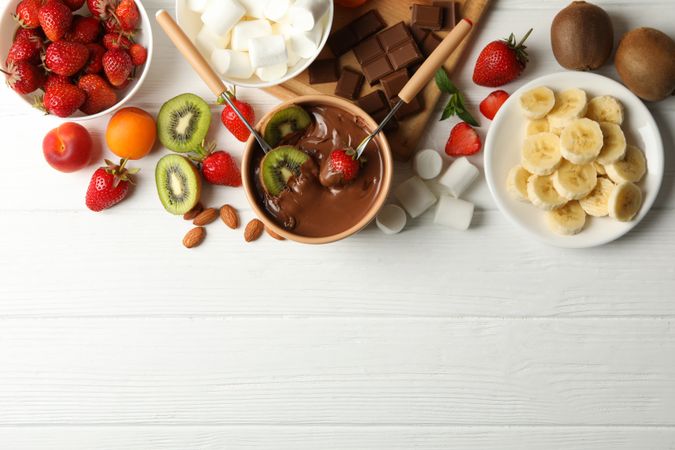 Composition with ingredients for chocolate fondue on wooden background. Cooking fondue