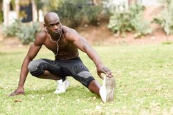 Male exercising with shirt off listening to music on headphones