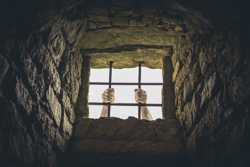 Man grabbing prison bars