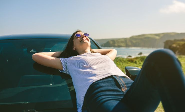 Young woman lying on the windshield