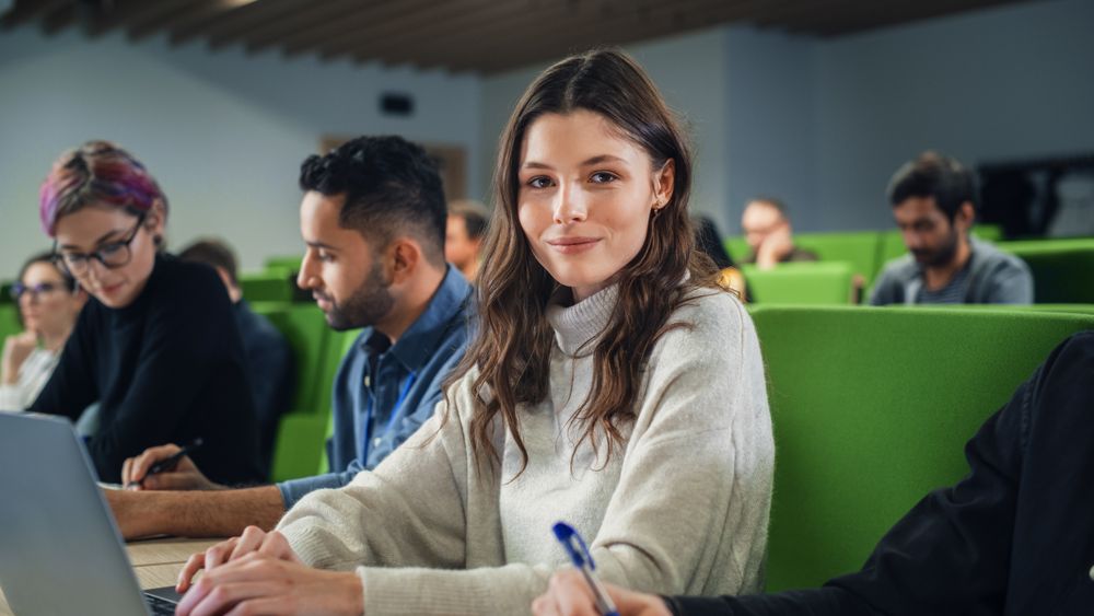 Smart Female Student Studying in University with Diverse Multiethnic Classmates.