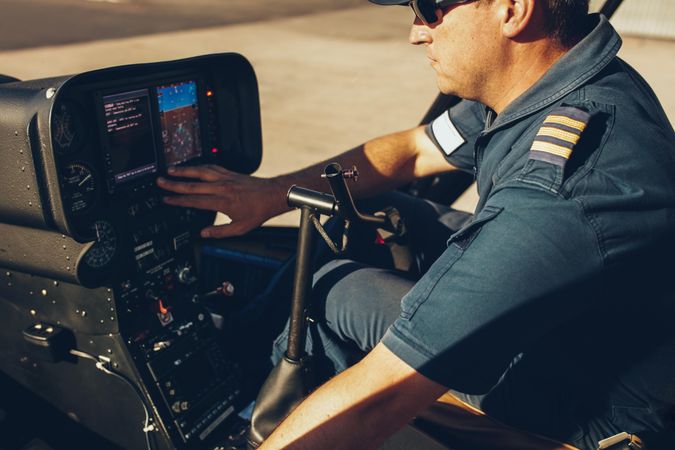 Pilot prepping helicopter controls on ground
