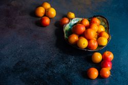 Bowl of plums on dark counter