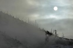 Sunrise through mist and clouds over a hill in Yellowstone National Park