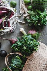 Overhead shot of grocery shopping jute and mesh bags overflowing with fresh produce