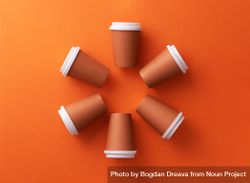 Disposable coffee cups on orange background in circle shape 4mD7v5