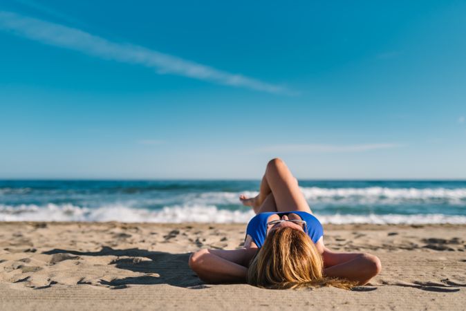 Woman lying down on sandy beach