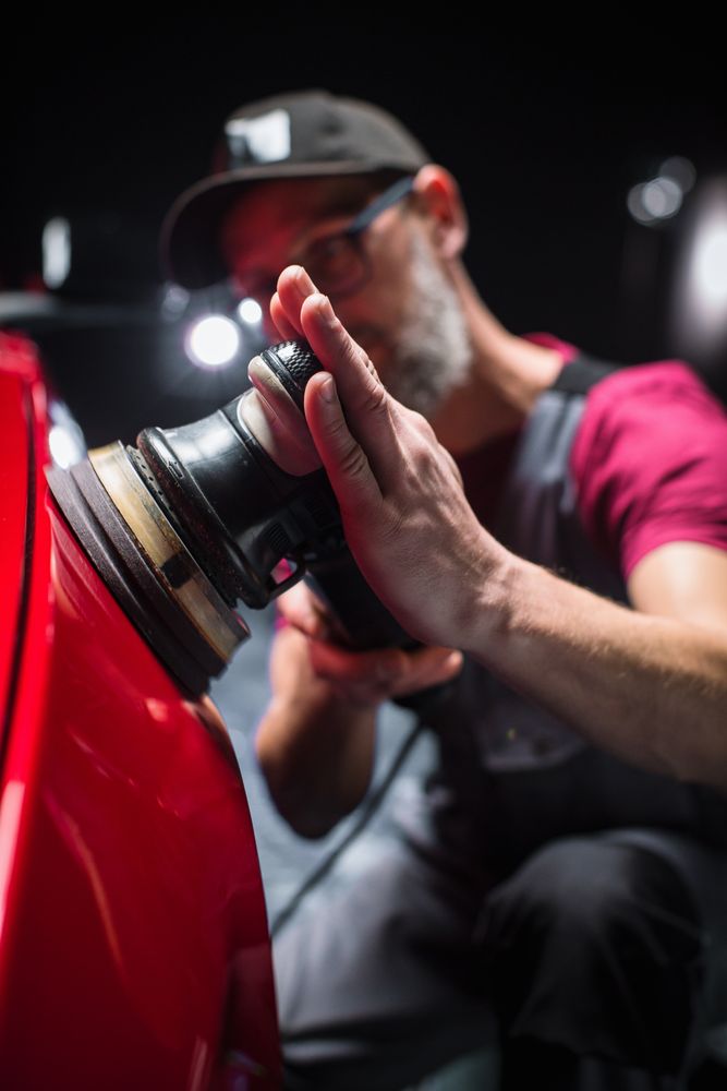 Professional Worker Buffing the Body from Light Scratches, Removing Swirls and Paint Defects from a Fender of the Vehicle