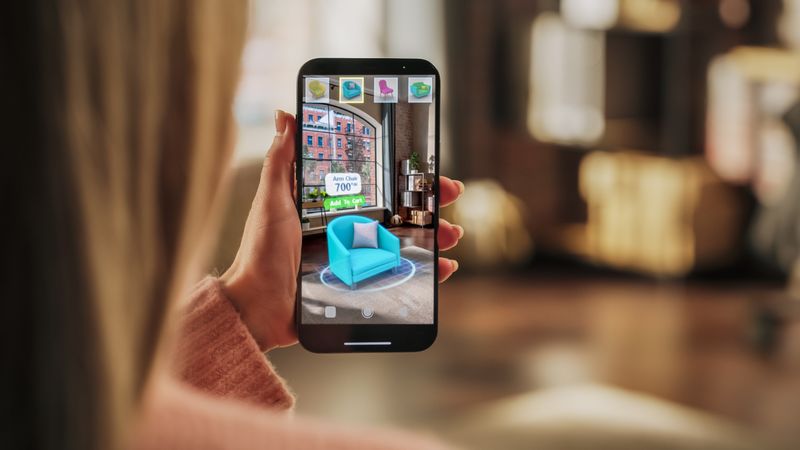 Decorating Apartment: Woman Holding Smartphone, using Augmented Reality Interior Design Software Chooses 3D Furniture for Home.