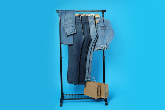 Jeans hang on hangers on a blue background