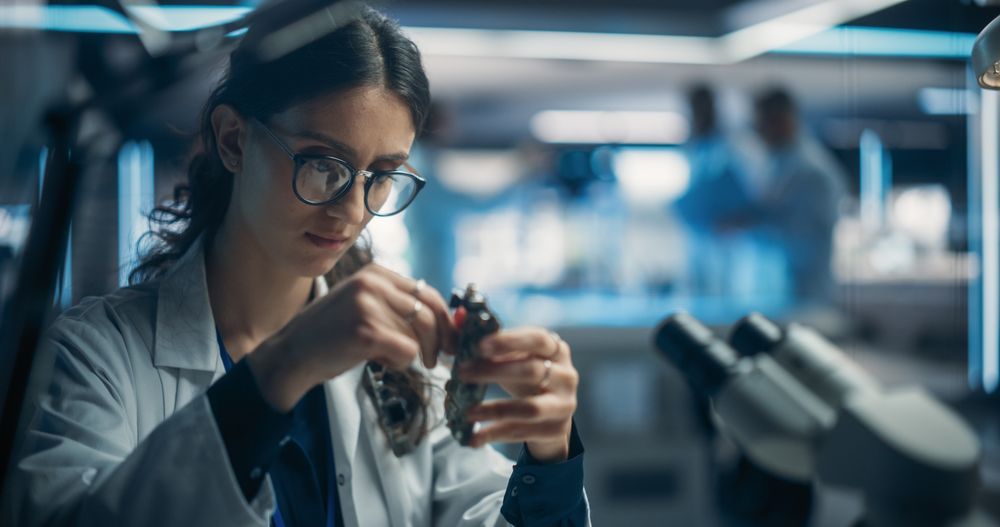 Focused Professional Female Engineer Working on Electronic Circuit Boards.