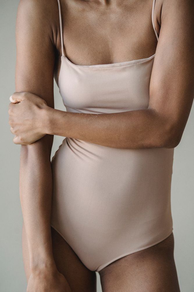 Cropped image of woman wearing beige leotard