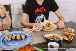 Cropped image of young man eating with chopsticks 0VyqGb