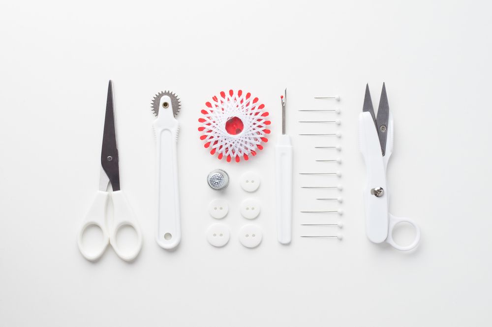 Sewing tools organized over light background