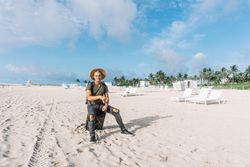 Very handsome young man looking at the camara, posing on the beach