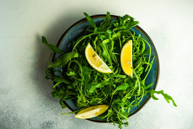Top view of rocket salad with lemon slices