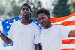 Black men in American Flag outside