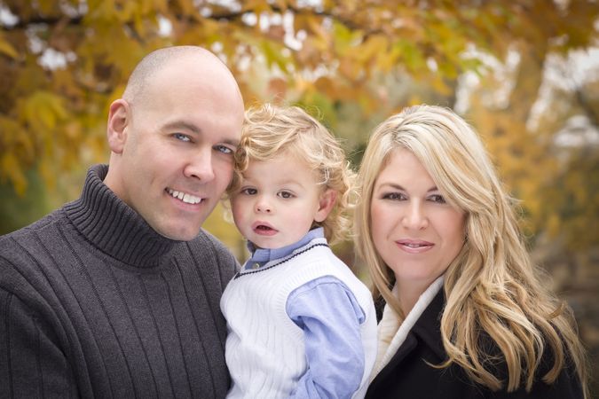Smiling Parents and Child Portrait in Park