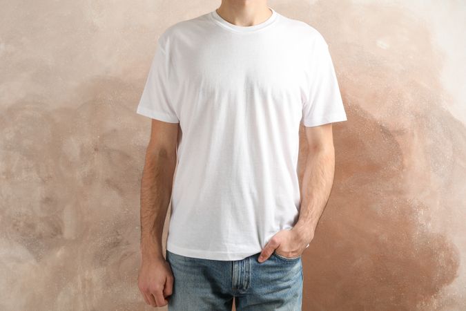 Men in blank t-shirt against brown background, space for text