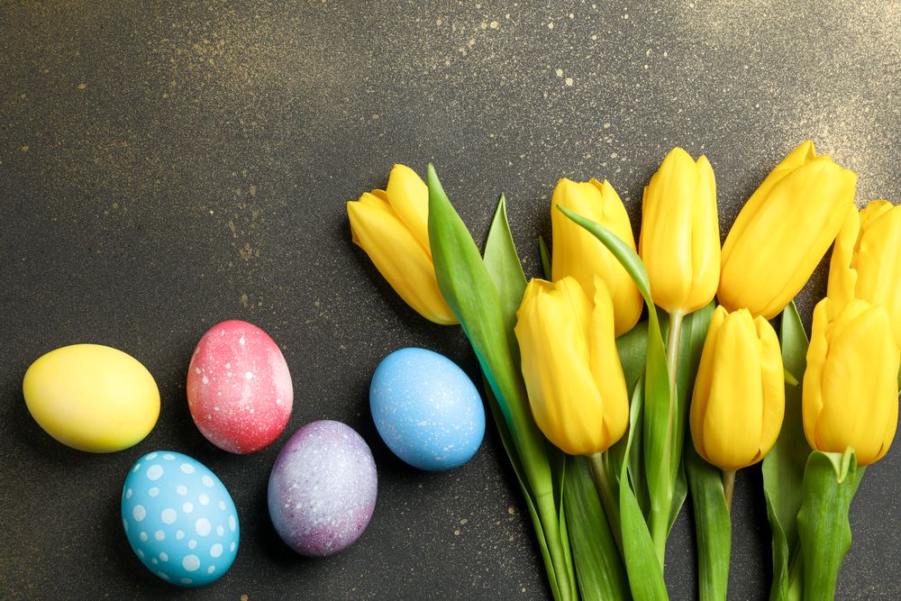 Decorated eggs with flowers on golden background. Space for text