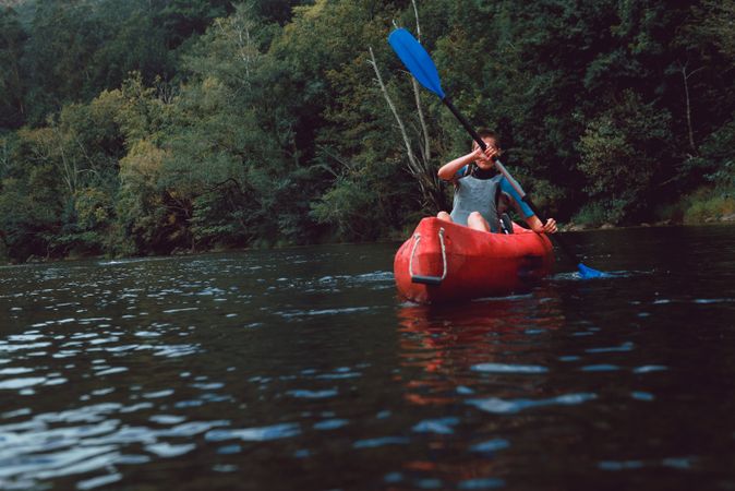Young female kayaking on nature background