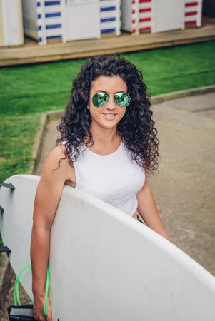 Brunette woman surfer holding surfboard