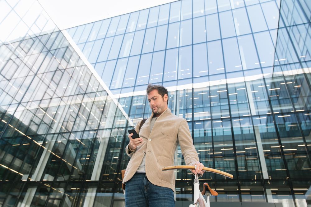 Man phoning while standing against modern building in downtown