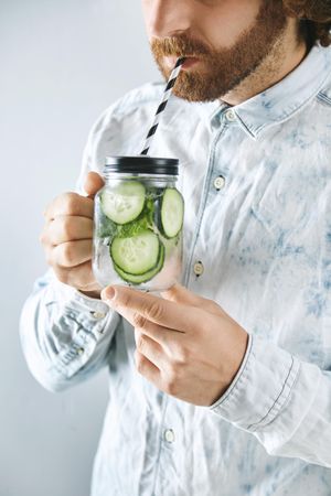 Man drinking cucumber infused water