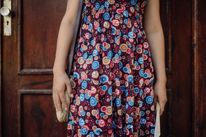 crop woman leaning on brown wooden door