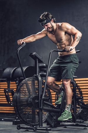 Hardworking male working out on gym bike