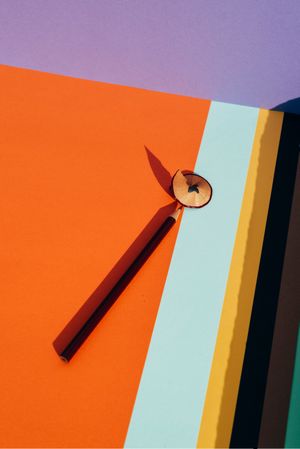 Pencil and shavings from sharpening, on colored striped papers