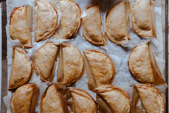 Baking tray with composed freshly baked pies patty