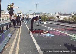 London, England, United Kingdom - April 19th, 2019: Woman lies on street as onlookers take photos 4BaY35