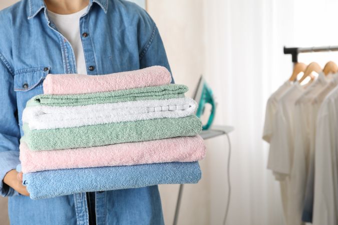 Young woman hold clean towels, close up and space for text