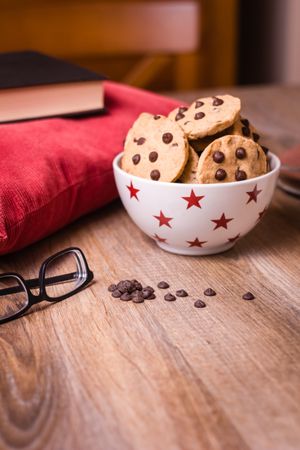 Chocolate chip cookies and milk on wood background