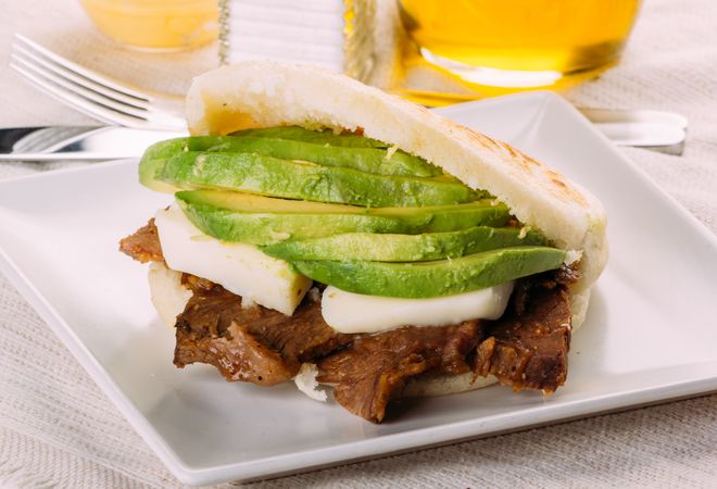 Delicious Arepa stuffed with avocado, cheese and meat