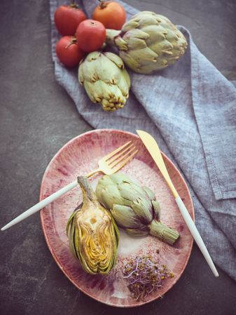 Delicious artichokes near ripe tomatoes
