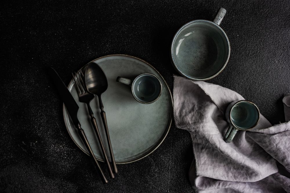 Grey table setting with dark cutlery and napkin
