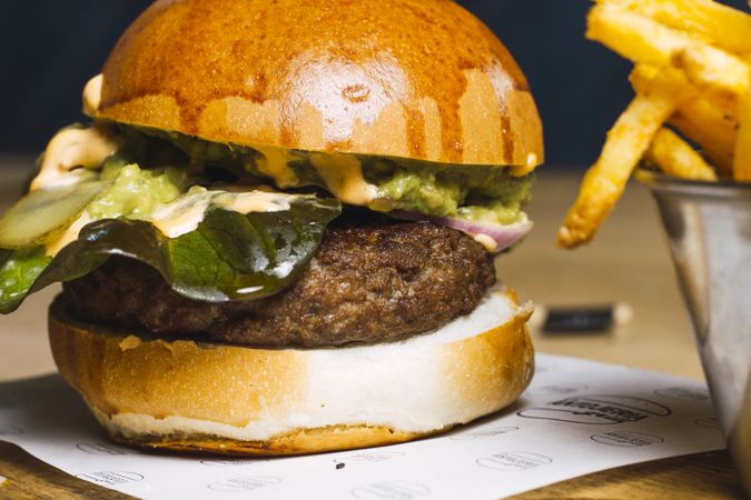 Juicy delicious burger and fried potato on table